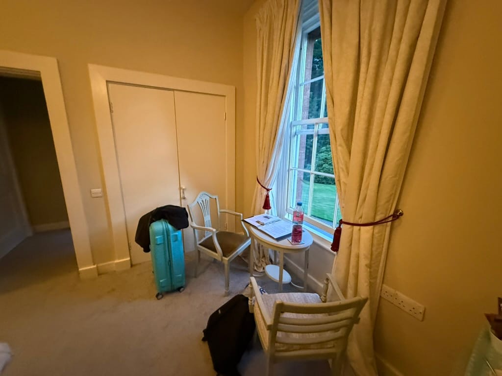 Desk and chairs beside a window in a hotel room.