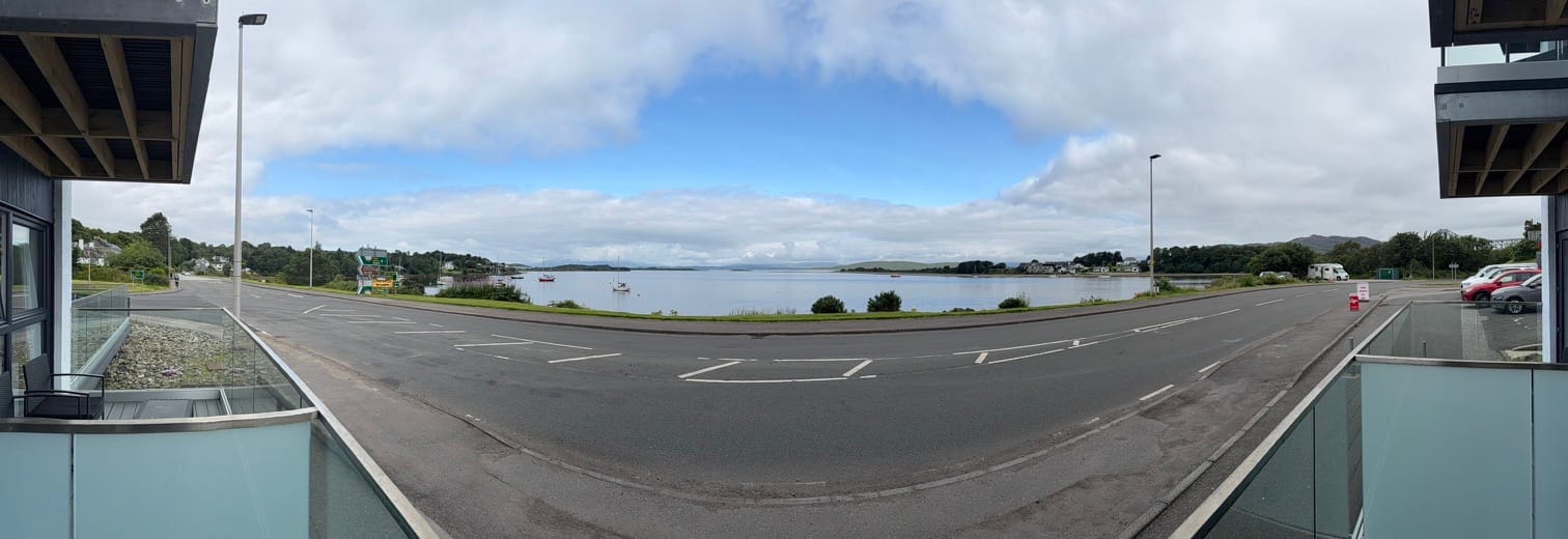 Panoramic view across a sea loch from a hotel balcony.