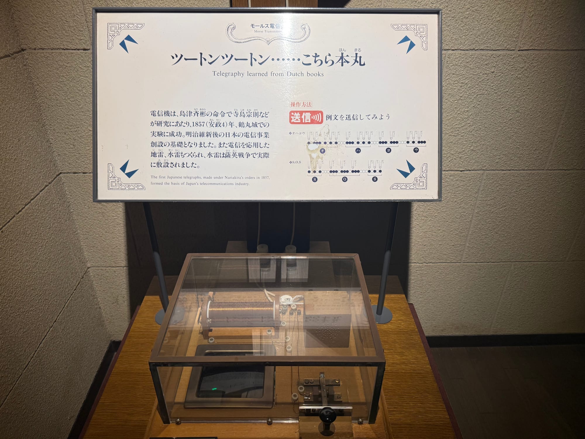 Morse telegraph exhibit at the Museum of the Meiji Restoration in Kagoshima, featuring an early telegraph apparatus and information explaining Japan's first telegraph experiments.