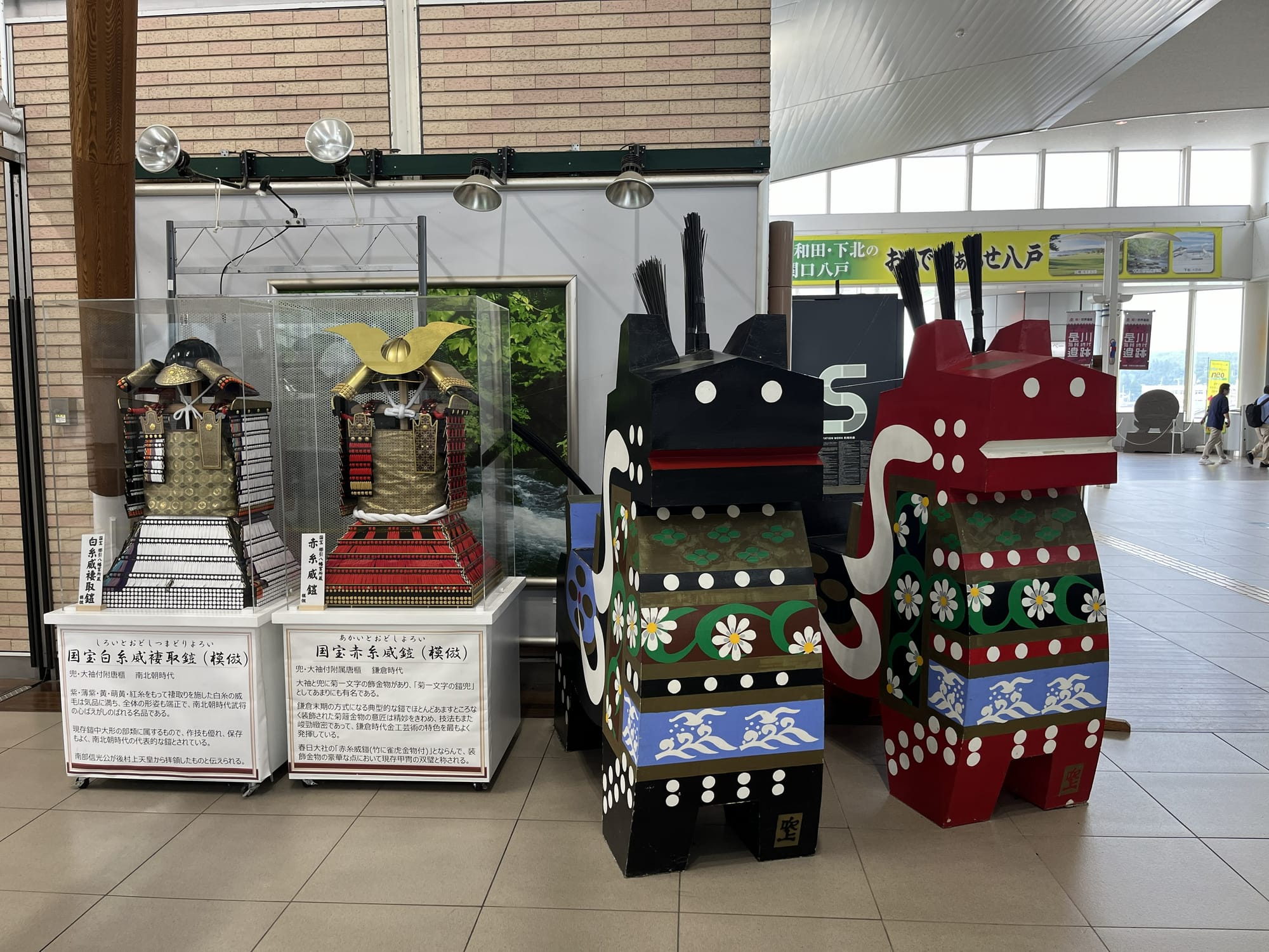 Traditional Japanese armour and colourful festival displays at Hachinohe Station, showcasing local heritage through historic replicas and decorative cultural exhibits.