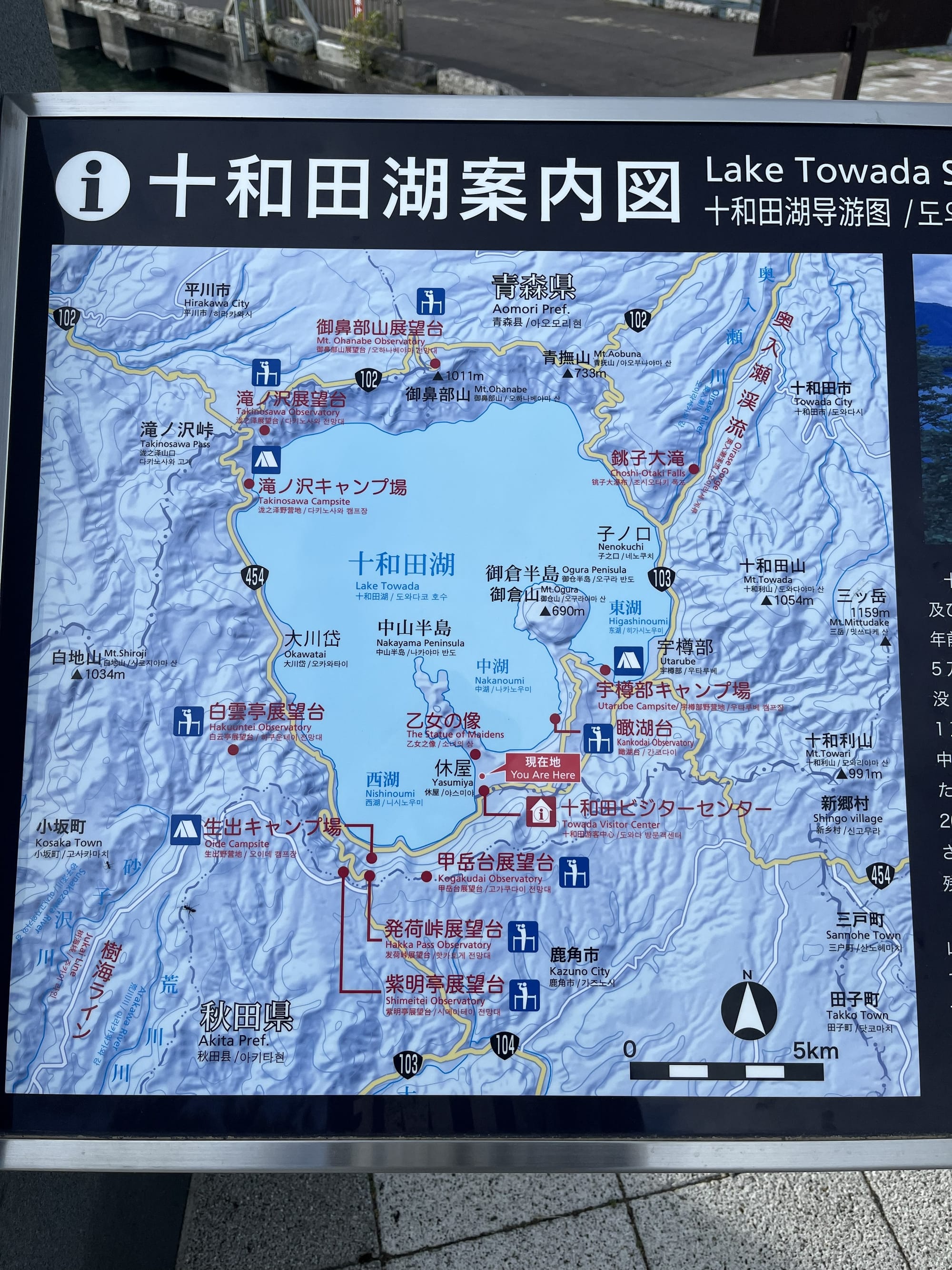 Tourist information map of Lake Towada showing viewpoints, campsites, roads and attractions around the caldera lake on the border of Aomori and Akita prefectures.