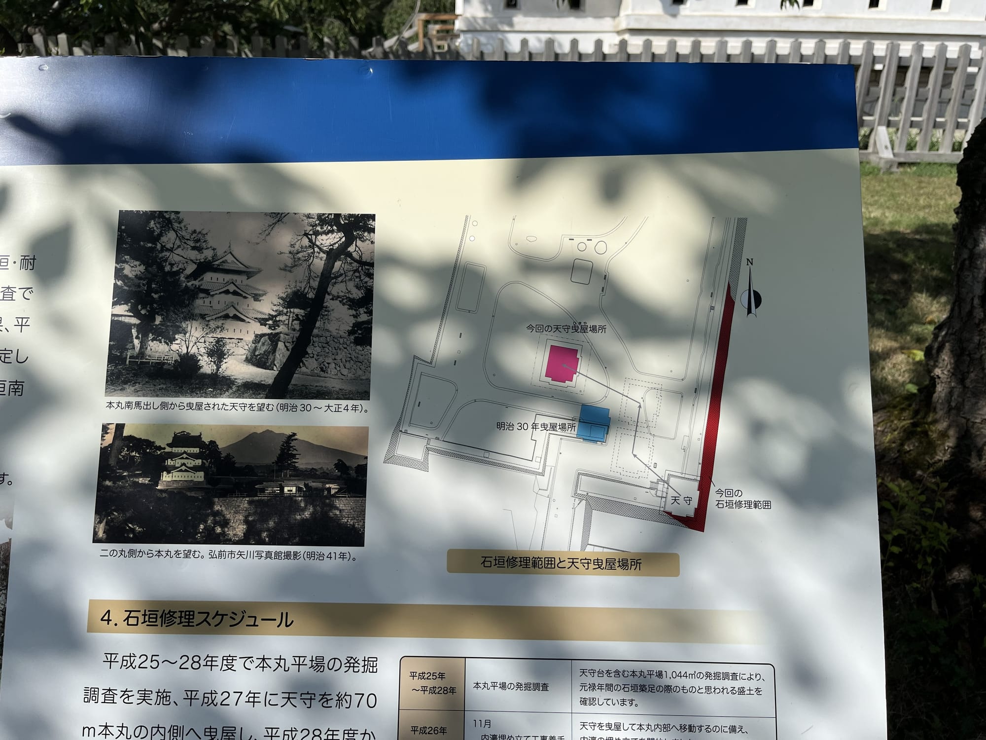 Information board at Hirosaki Castle showing historical photographs, a site map and details of restoration work, explaining the relocation of the castle keep.