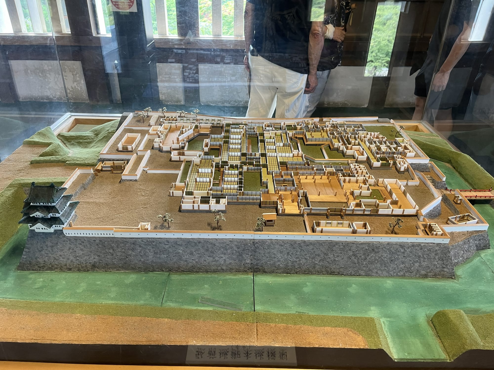 Scale model of Hirosaki Castle and its surrounding palace complex, showing defensive walls, gates, buildings and streets within the historic castle grounds.