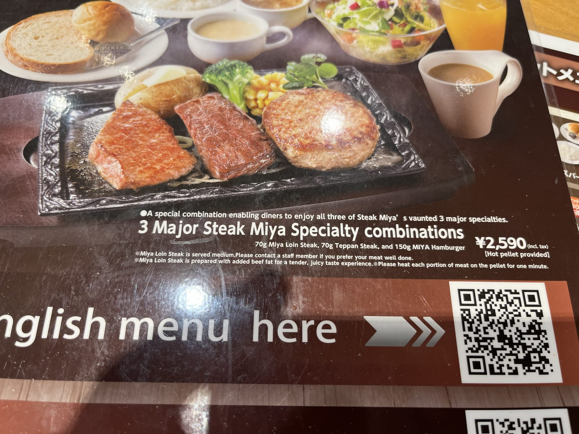 Restaurant menu at Steak Miya showing a combination meal with steak, hamburger steak, vegetables, soup, salad, bread and rice, alongside an English menu QR code.