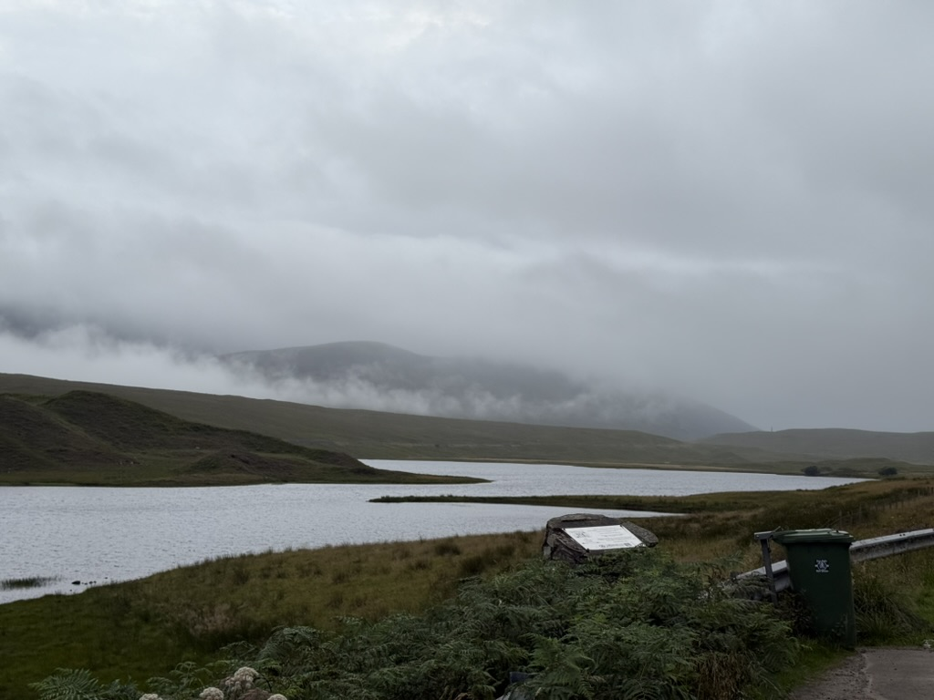 Misty loch in the Scottish Highlands beneath low cloud.