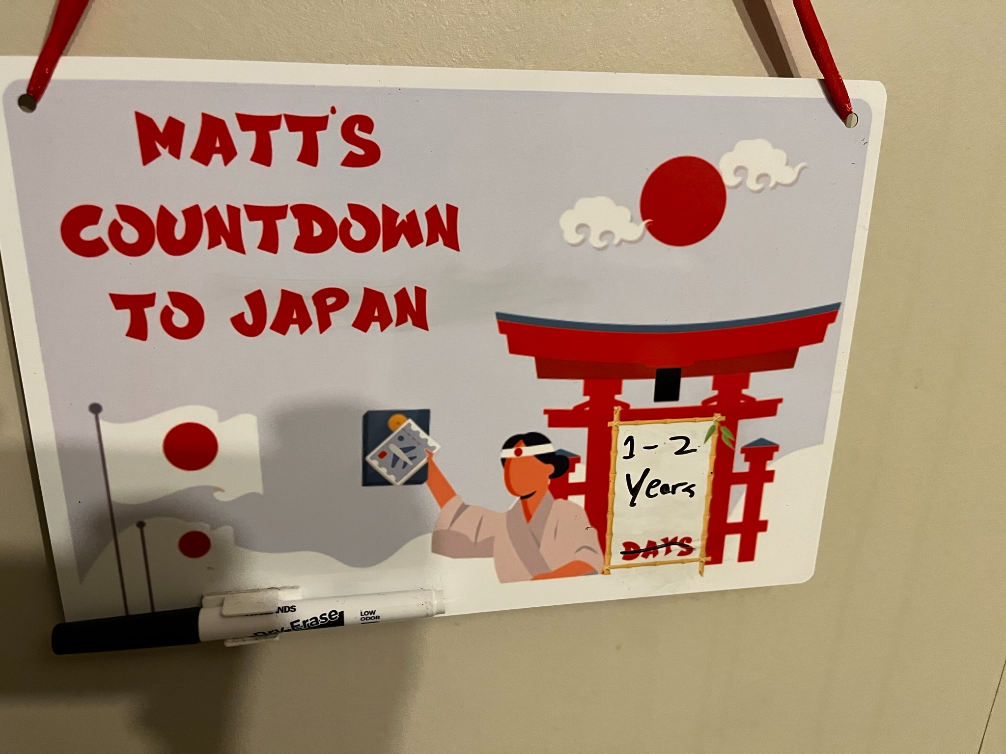 Custom whiteboard countdown to Japan featuring a torii gate, Japanese flag and travel-themed illustrations, showing the final stages of preparation before a trip.