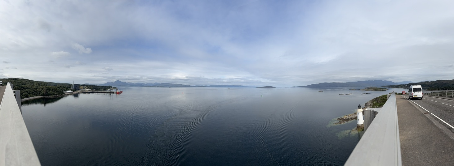 Panoramic view from the Skye Bridge across Loch Alsh with lighthouse and distant mountains.