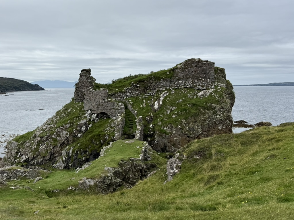 Ruins of Dunscaith Castle on a rocky sea stack on the Isle of Skye.