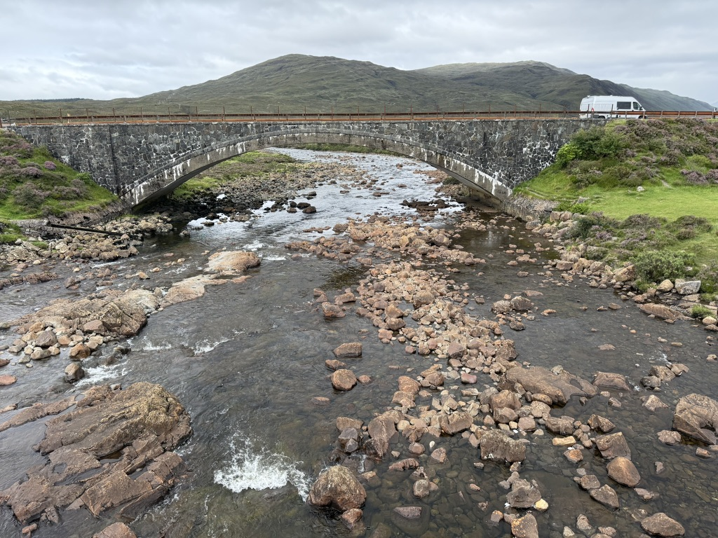 Old stone bridge at Sligachan spanning a rocky river on the Isle of Skye.