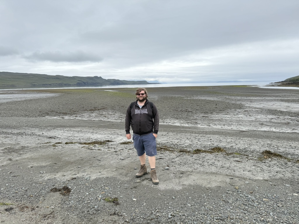 Person standing on the tidal flats at Glen Brittle on the Isle of Skye.