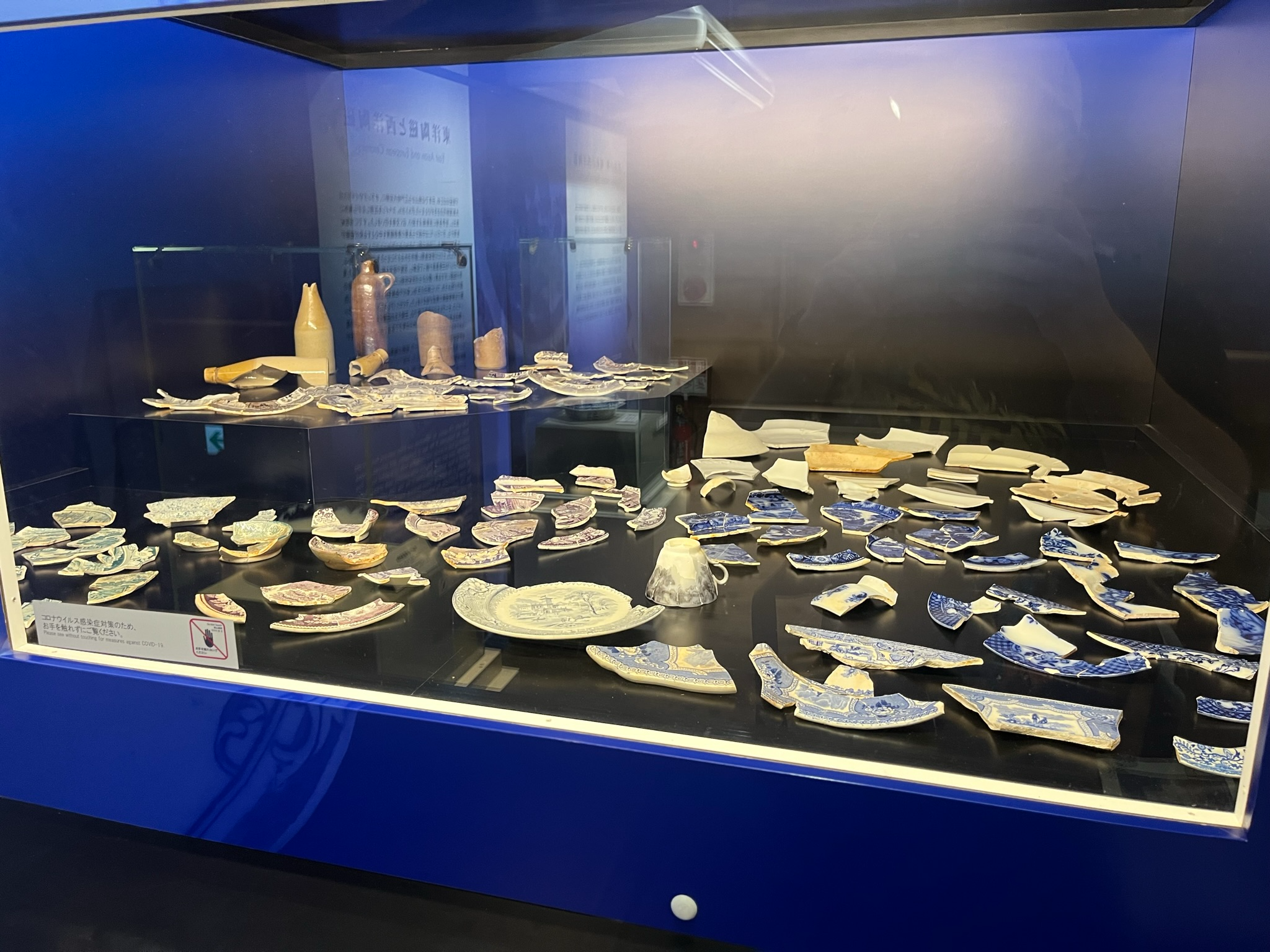Museum display at Dejima featuring excavated ceramic fragments, pottery shards and tableware recovered from the historic Dutch trading post in Nagasaki.