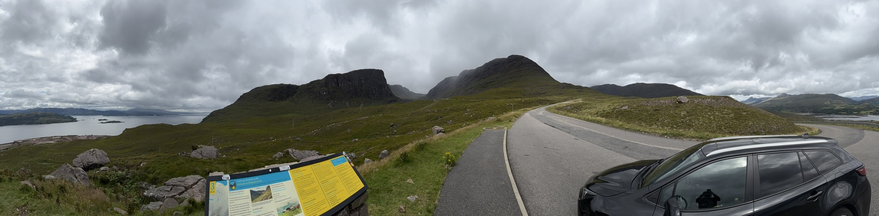 Panoramic view from the Bealach na Bà with mountain road, rugged peaks and Loch Kishorn below.
