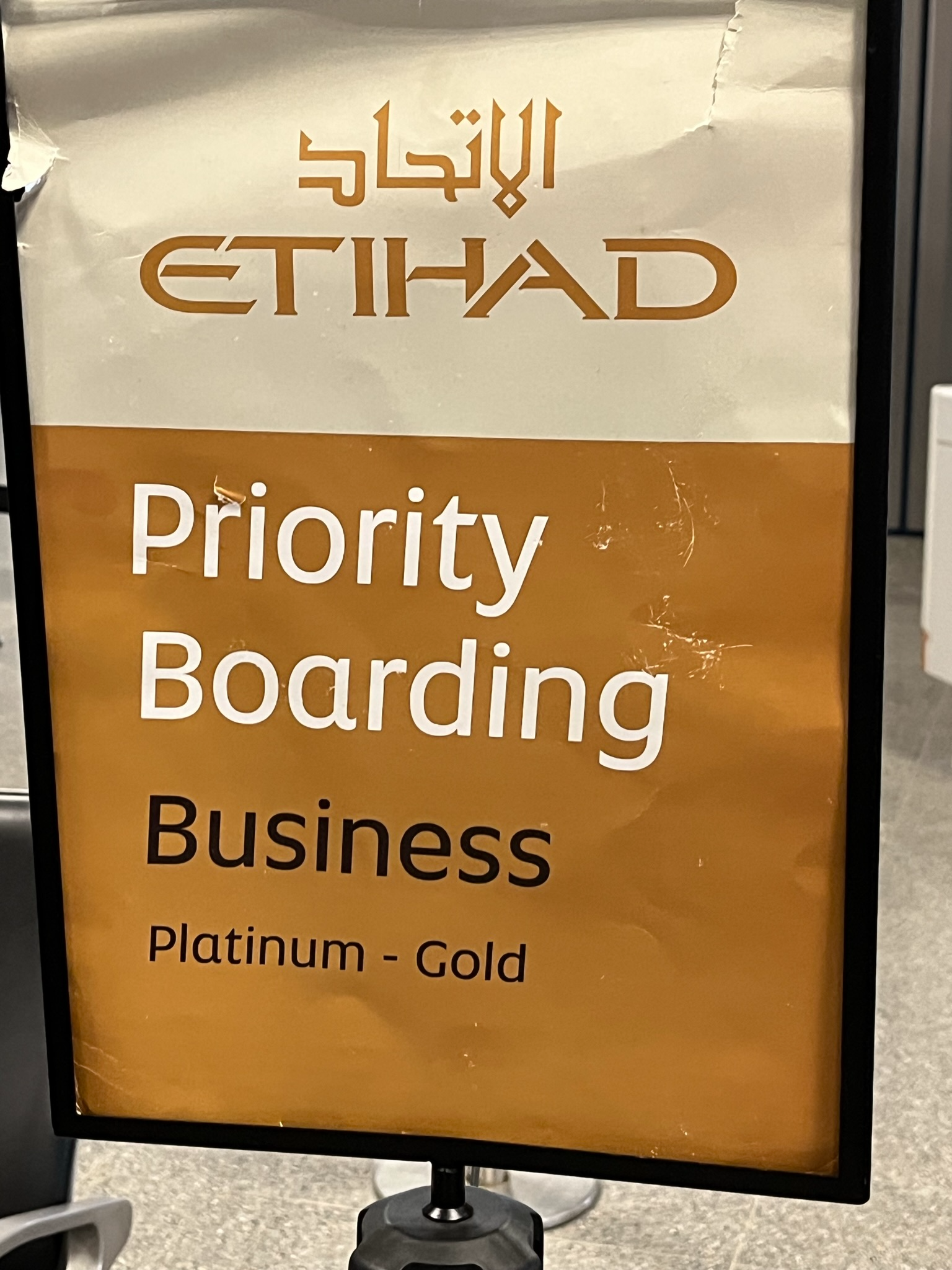 Etihad Airways priority boarding sign at an airport gate, indicating boarding access for Business Class passengers and eligible Platinum and Gold loyalty members.
