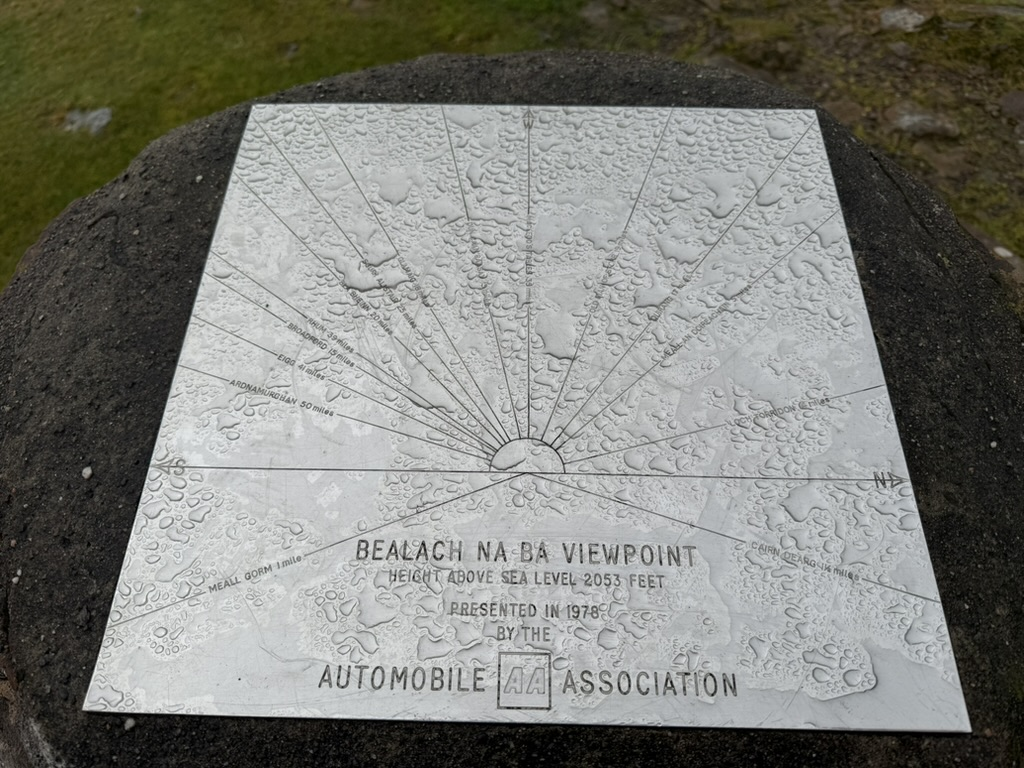 Bealach na Bà viewpoint plaque covered in raindrops.