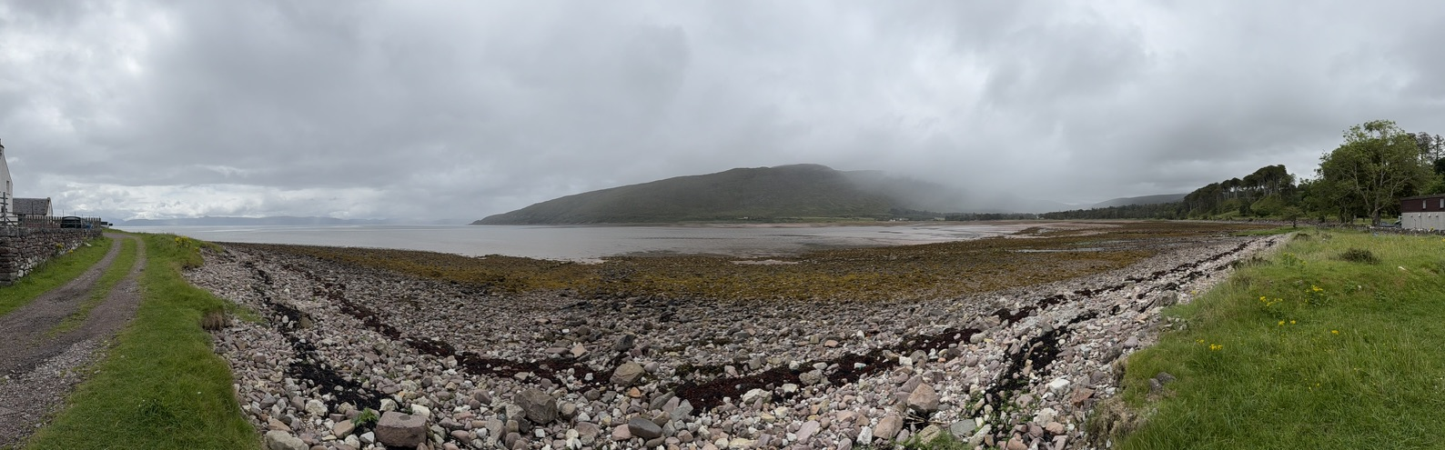 Rocky shoreline and bay at Applecross under dark storm clouds.