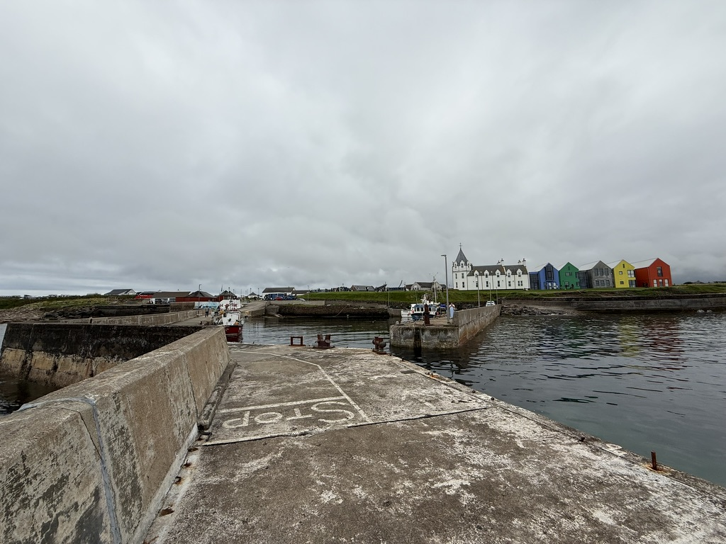 John O' Groats harbour with colourful waterfront buildings.
