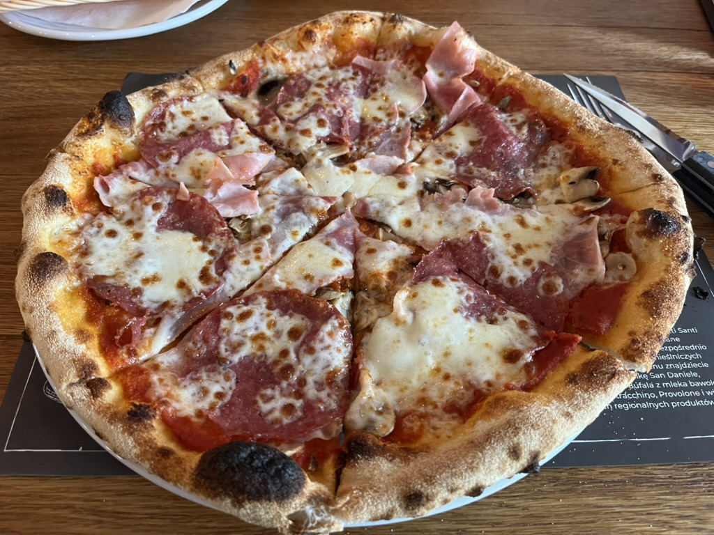 Pizza topped with salami, ham, mushrooms and melted mozzarella.