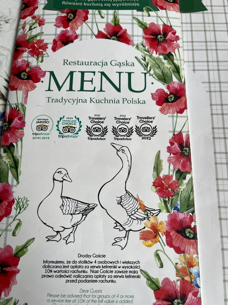 Cover of a Polish restaurant menu decorated with red flowers and illustrations of two geese.