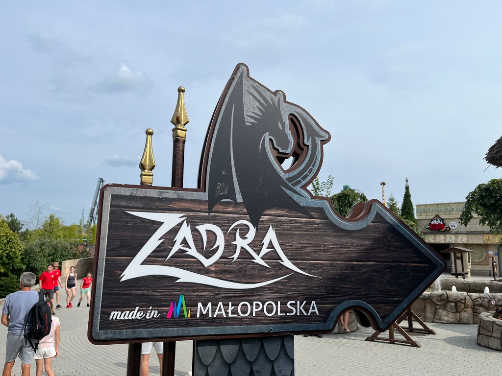 Sign for Zadra at Energylandia, featuring a stylised dragon and wooden arrow design with the text “Made in Małopolska”.