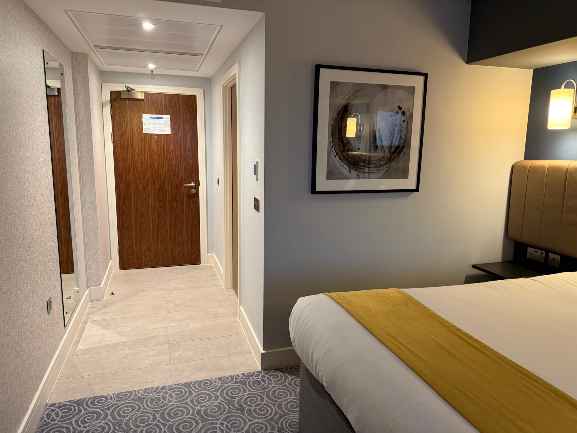 Modern hotel room with king-size bed and contemporary décor.