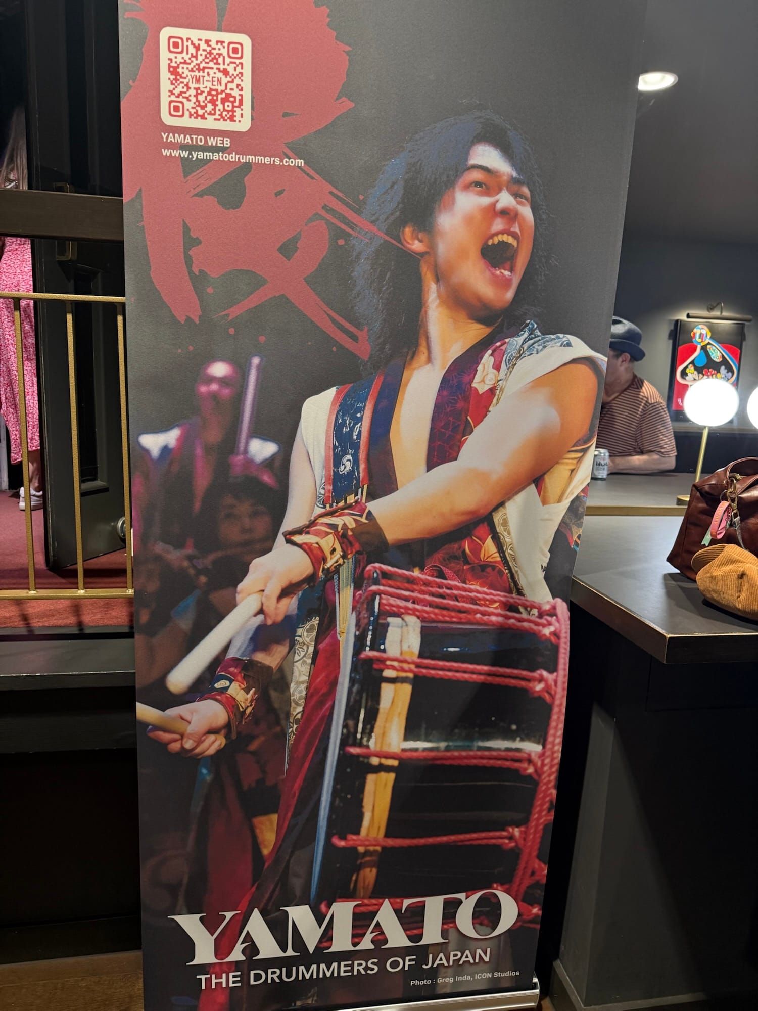 Yamato Drummers of Japan promotional banner with performer playing a taiko drum.