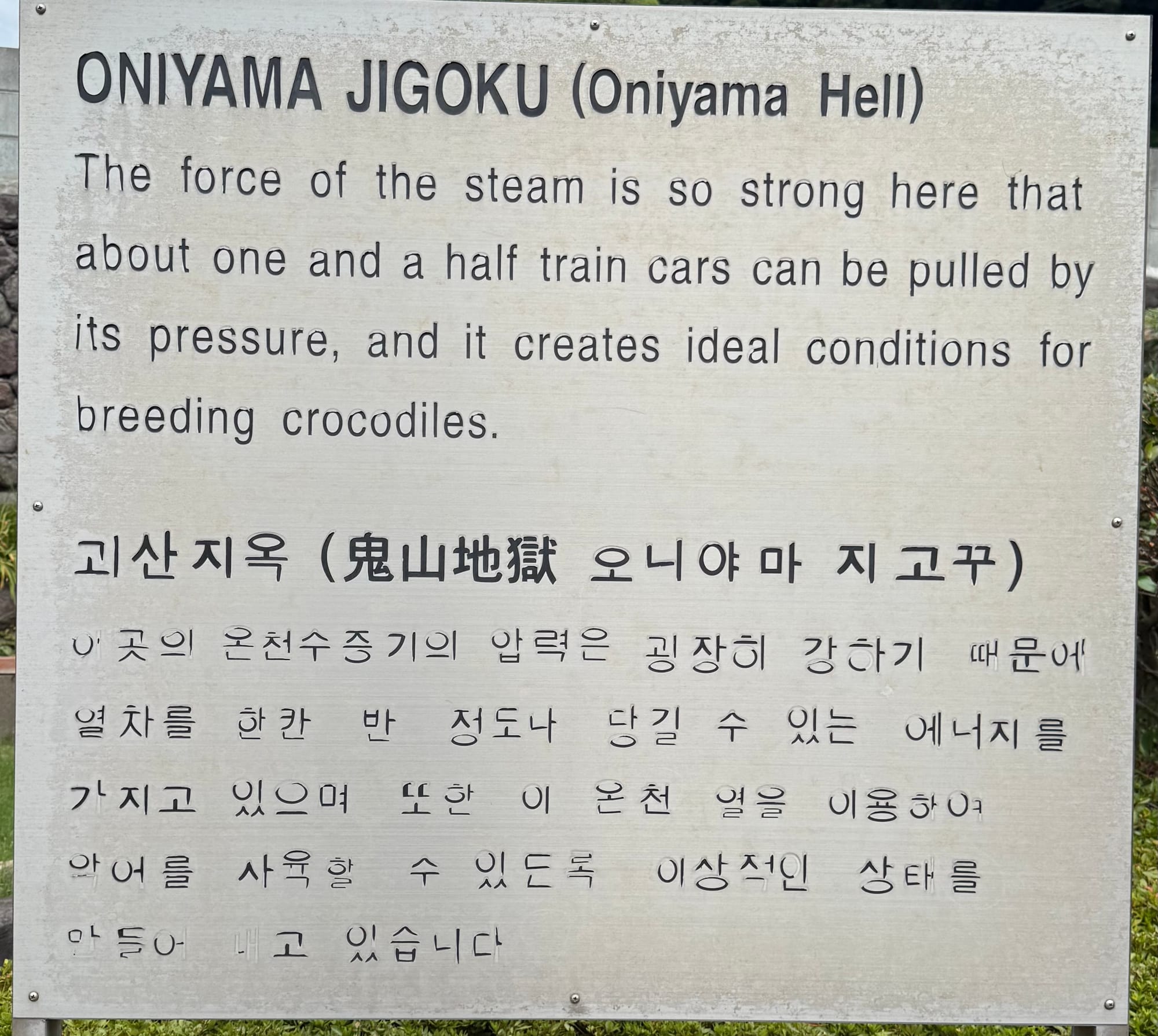 Information sign for Oniyama Jigoku (Oniyama Hell) in Beppu, explaining the powerful geothermal steam and its use in creating suitable conditions for crocodile breeding.