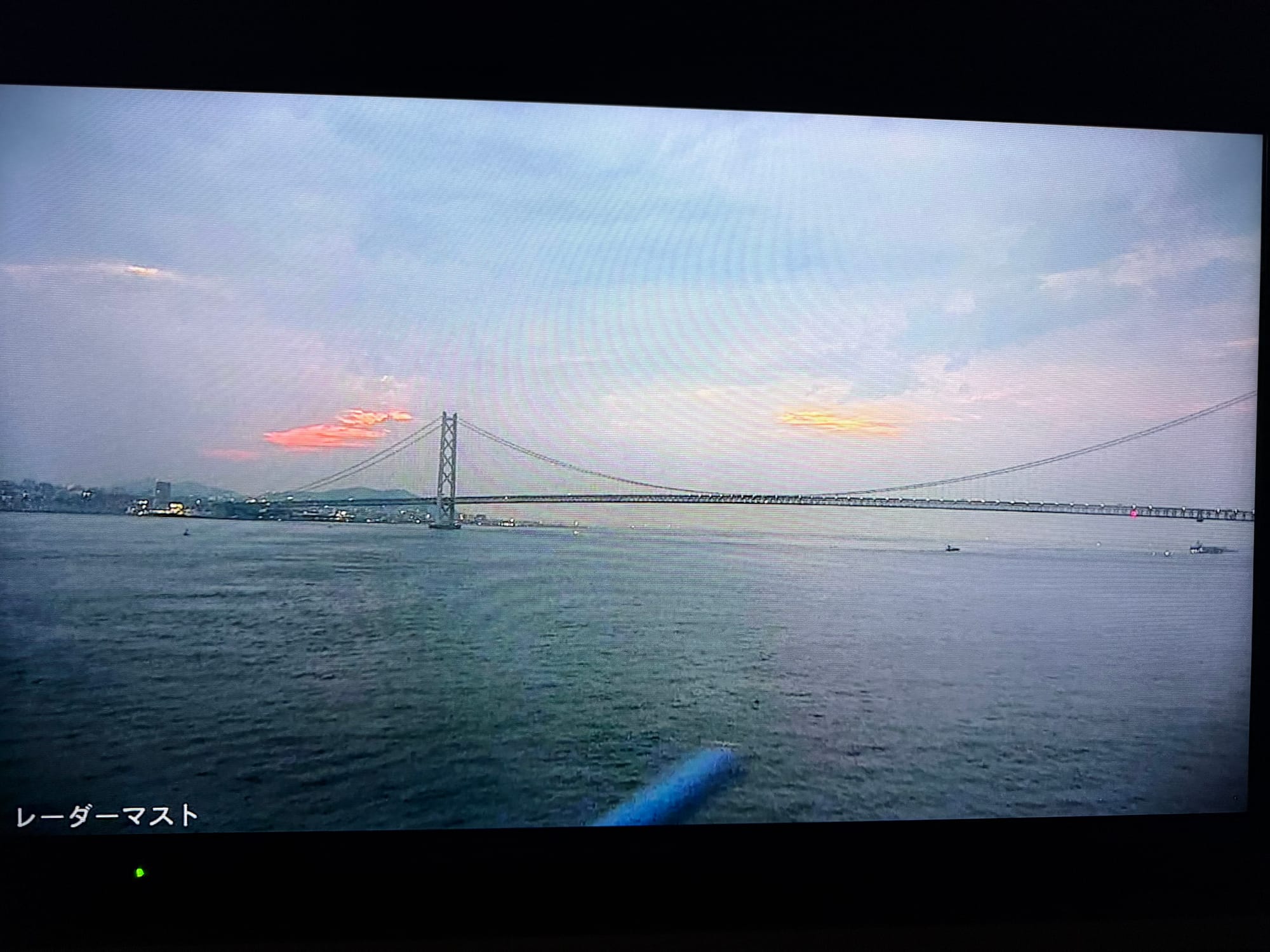 View from the Sunflower Ferry showing the Akashi Kaikyō Bridge spanning the Strait of Akashi at dawn, with calm waters and colourful early morning skies.