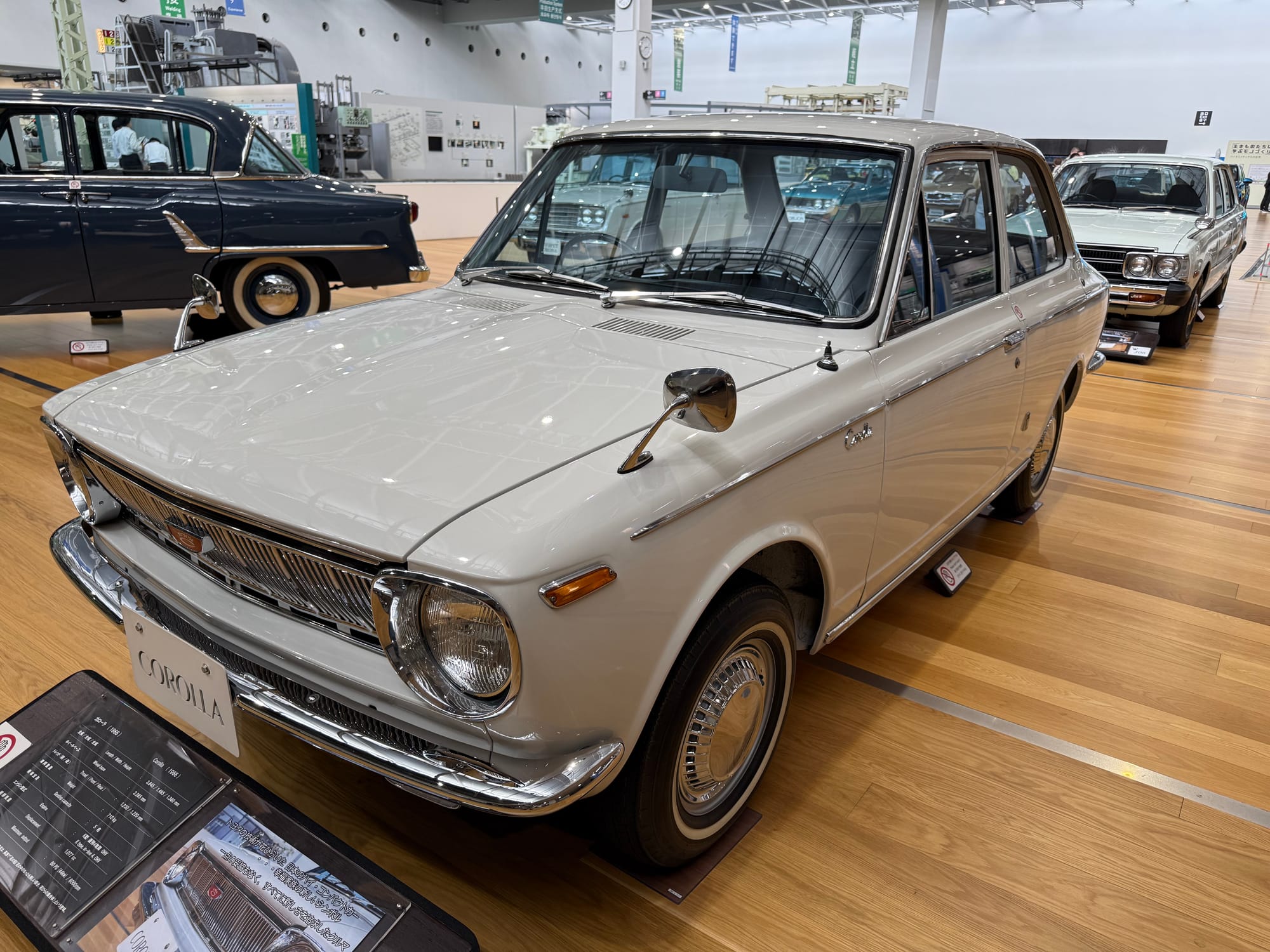 First-generation Toyota Corolla on display at the Toyota Commemorative Museum of Industry and Technology, featuring white bodywork and the compact design that popularised motoring in Japan.