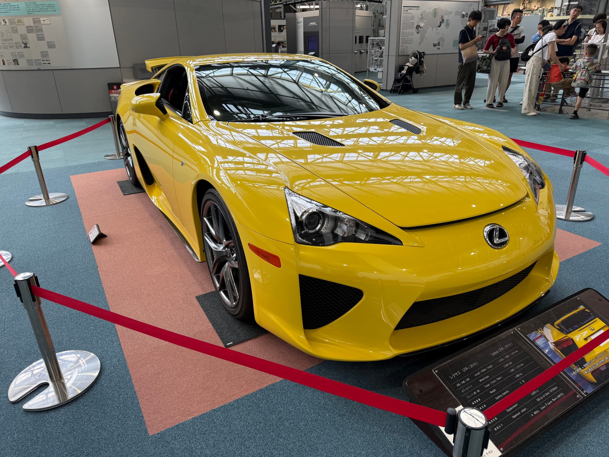 Yellow Lexus LFA supercar on display at the Toyota Commemorative Museum of Industry and Technology, featuring carbon-fibre bodywork and distinctive high-performance styling.
