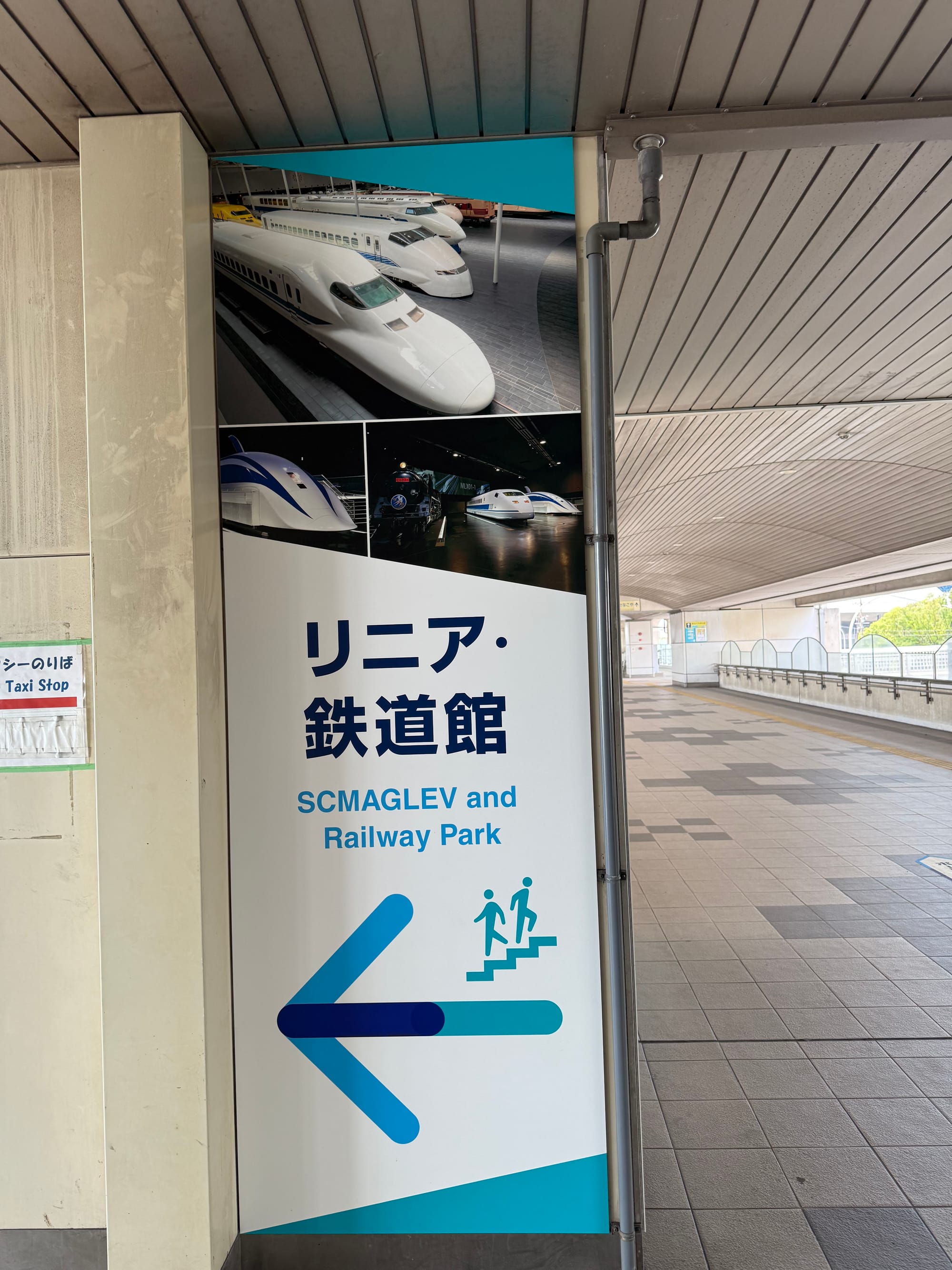 Sign at Kinjōfutō Station in Nagoya directing visitors to the SCMAGLEV and Railway Park, featuring images of Shinkansen trains and Japan's superconducting maglev.