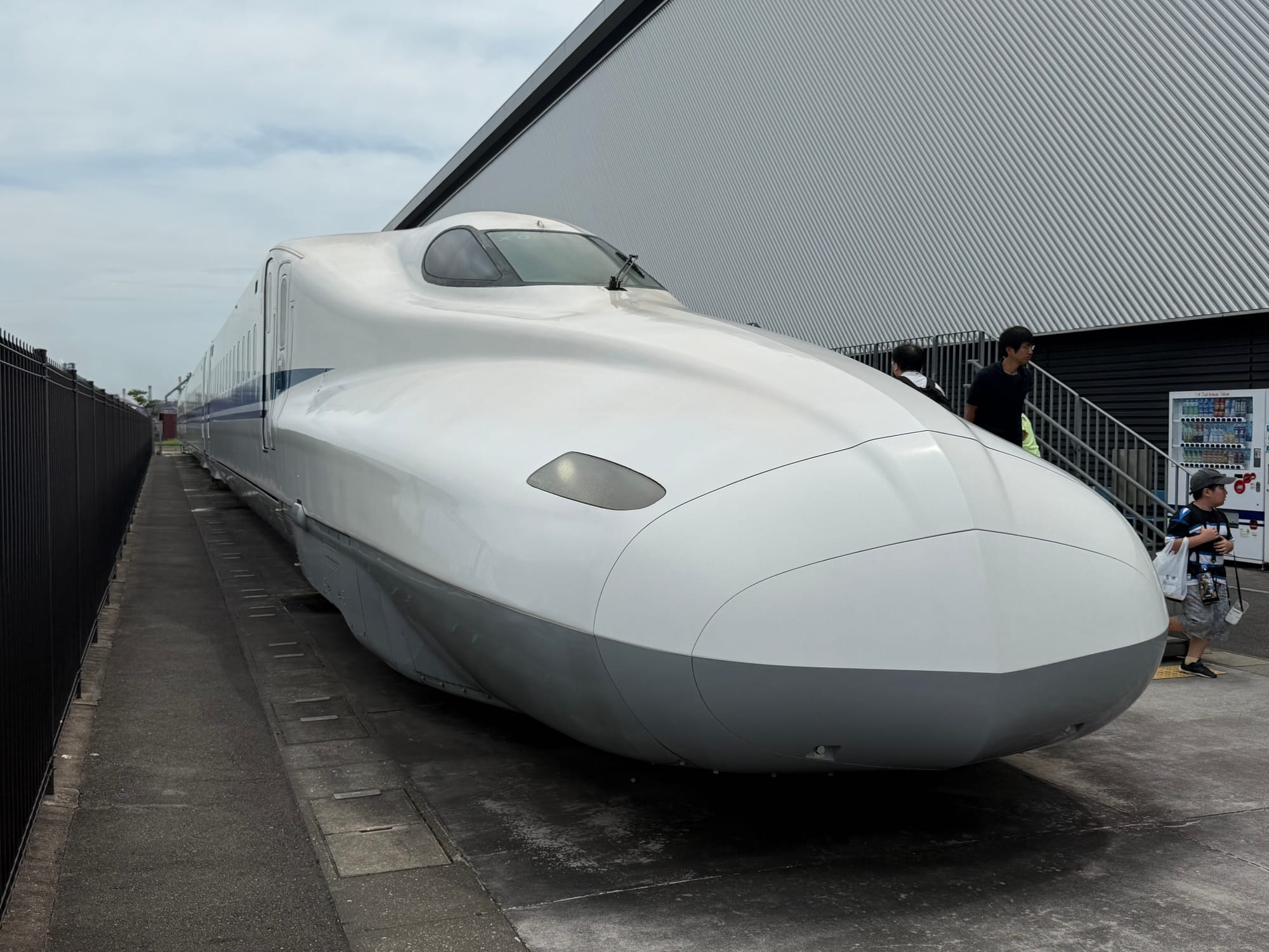 N700A Series Shinkansen displayed outside the SCMAGLEV and Railway Park in Nagoya, featuring its streamlined aerodynamic nose, white bodywork and blue stripe.