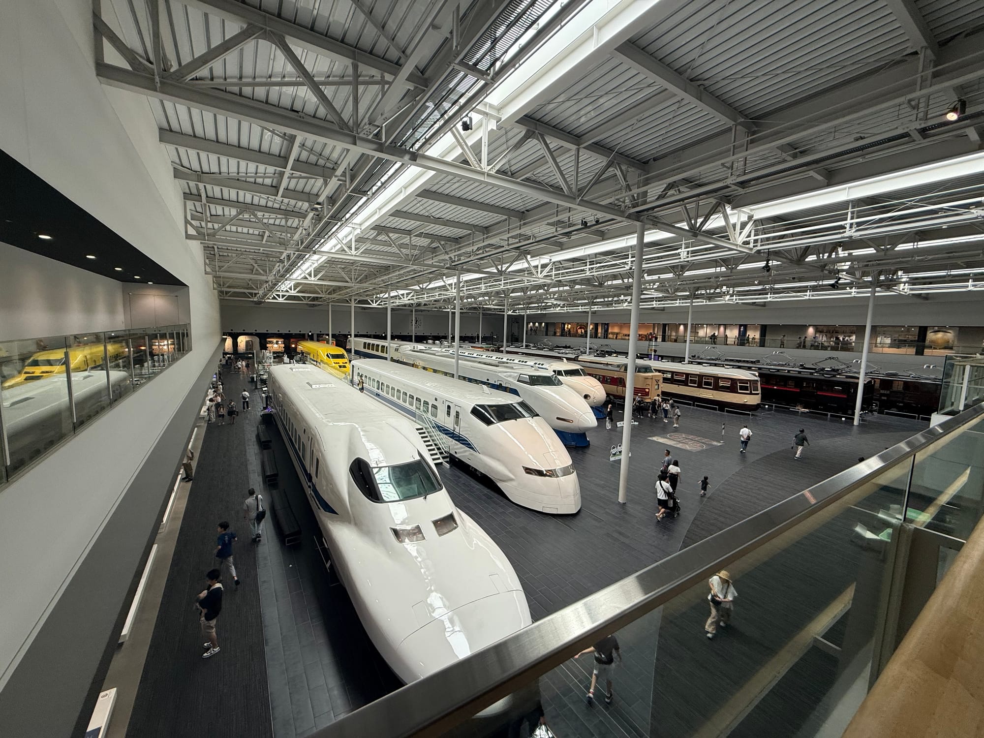 Wide view of the SCMAGLEV and Railway Park in Nagoya, displaying historic Shinkansen trains, Doctor Yellow and classic Japanese railway vehicles inside the museum's main exhibition hall.
