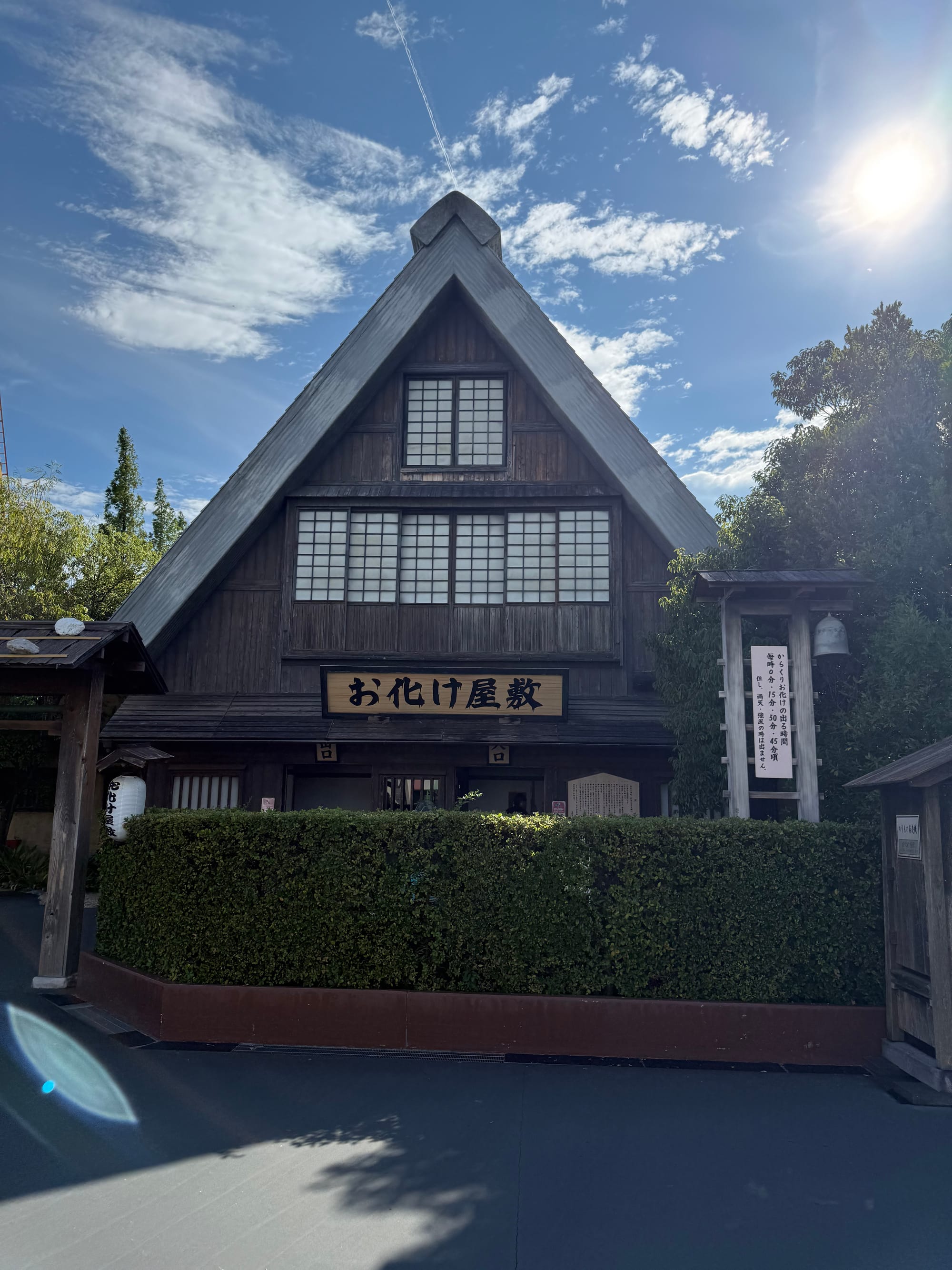 Traditional Japanese haunted house attraction at Nagashima Spa Land, housed in a steeply roofed wooden building with dark timber walls and signage above the entrance.