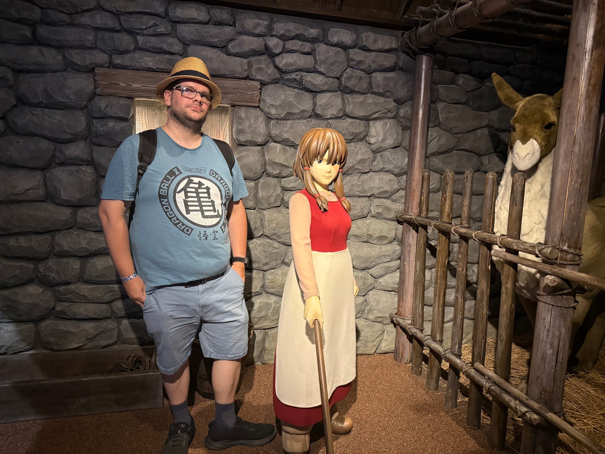 Visitor stands beside Therru and a horse in a stable scene from Tales from Earthsea in the Becoming Characters in Memorable Ghibli Scenes exhibit.