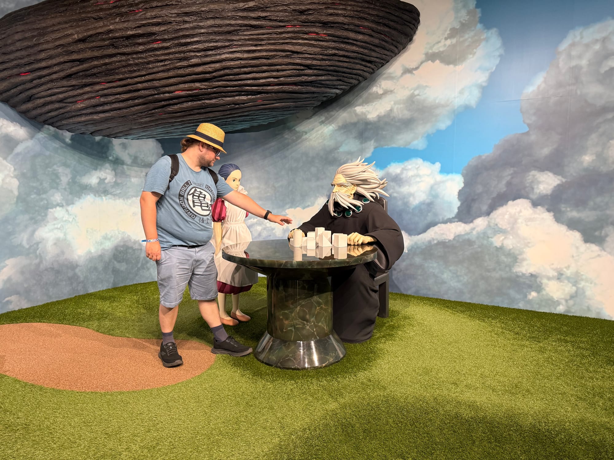 Visitor stands beside Mahito, Himi and the Great Uncle from The Boy and the Heron in the Becoming Characters in Memorable Ghibli Scenes exhibit at Ghibli Park.