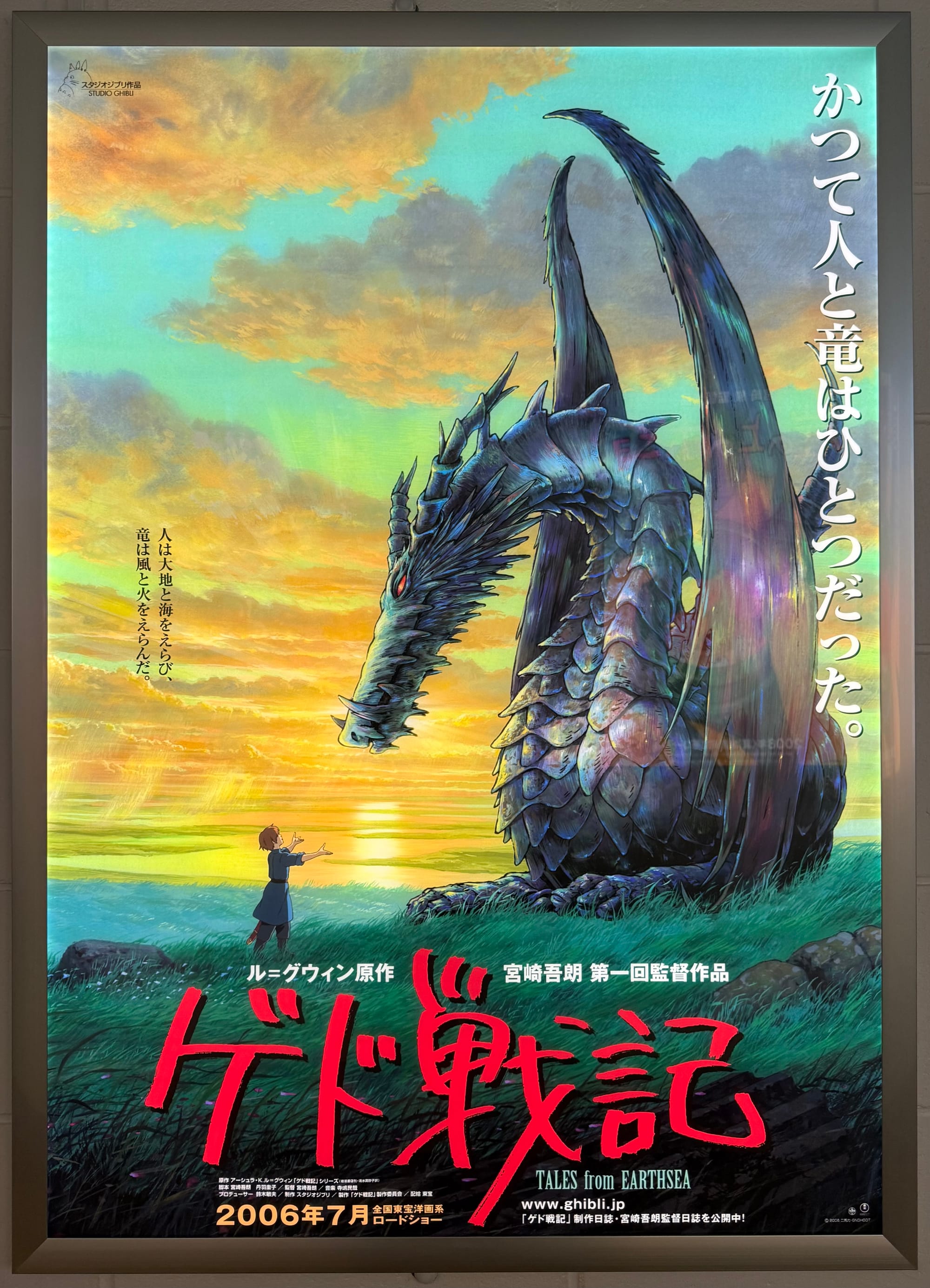 Film poster for Tales from Earthsea displayed at Ghibli Park's Grand Warehouse, showing a large dragon facing Arren beneath a dramatic sunset sky.
