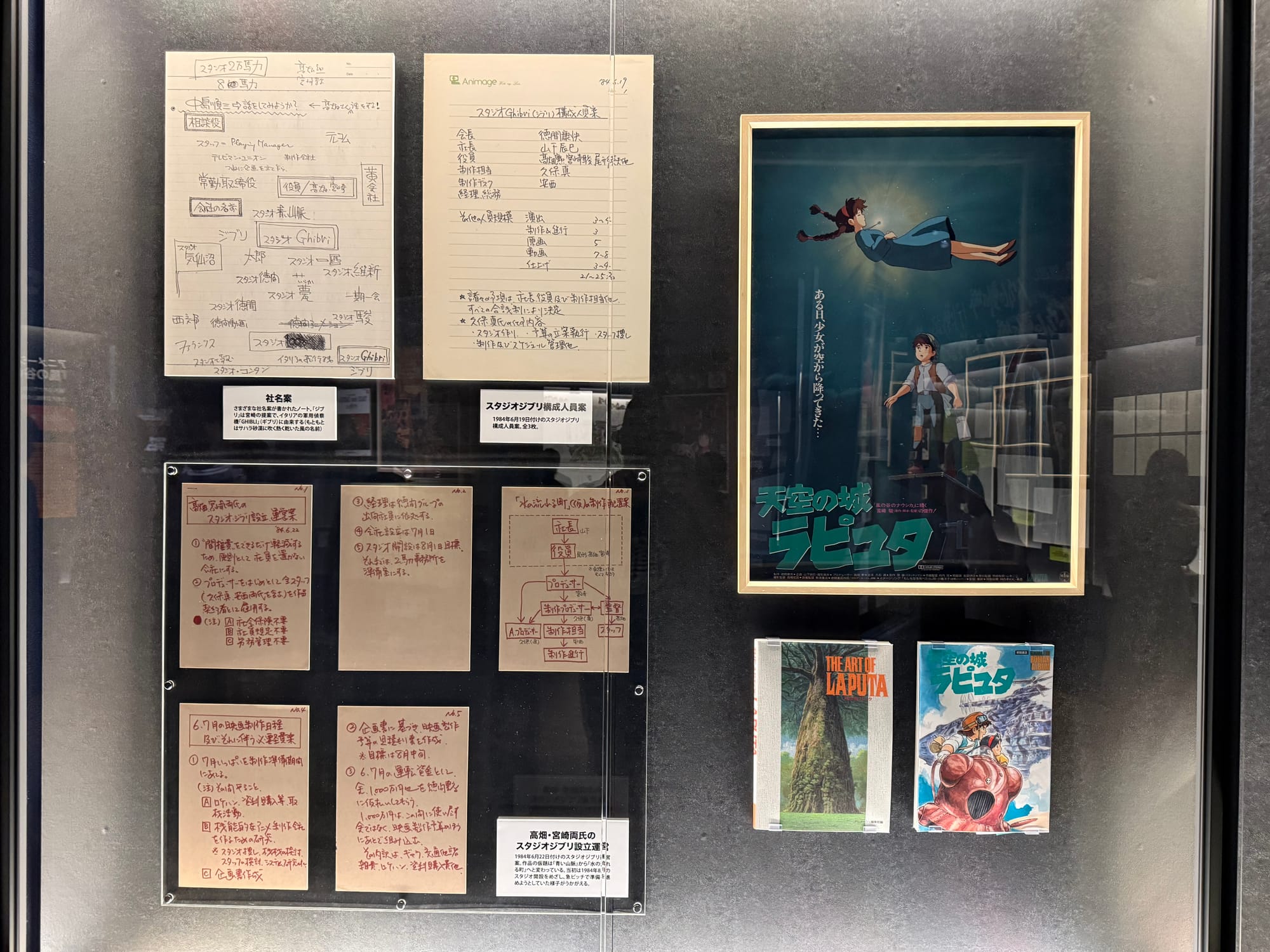 Studio Ghibli founding documents and Castle in the Sky materials on display at Ghibli Park's Grand Warehouse, including planning notes, a film poster and related publications.