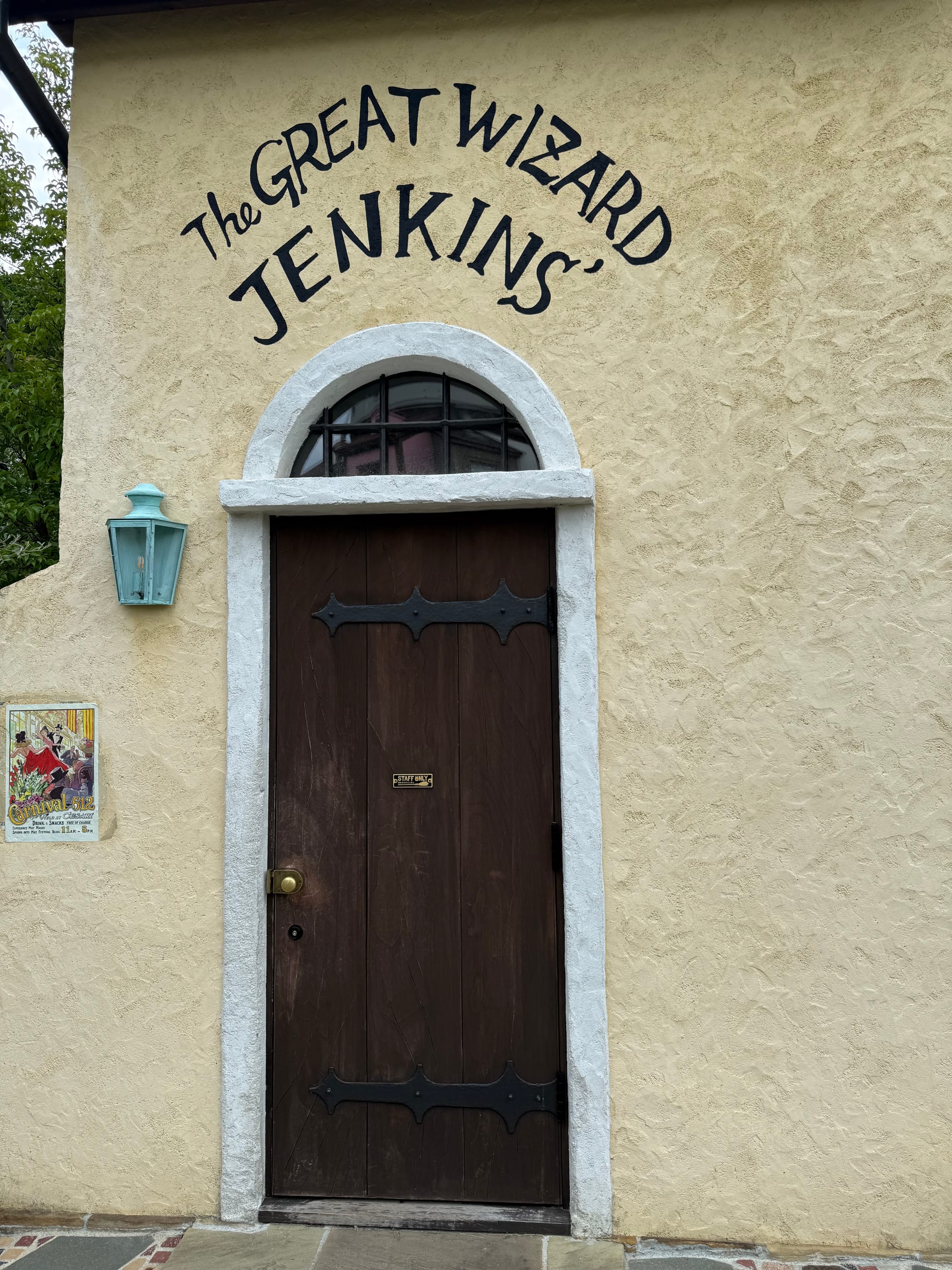 Doorway to The Great Wizard Jenkins' home from Howl's Moving Castle in Ghibli Park's Valley of Witches, featuring a wooden door set in a cream-coloured wall.