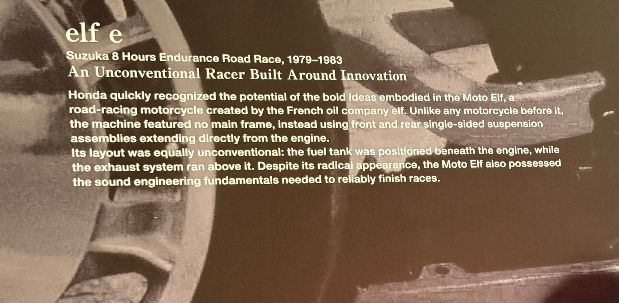 Interpretive display panel about the Honda elf e endurance racing motorcycle, explaining its frameless design, single-sided suspension and innovative engineering concepts.
