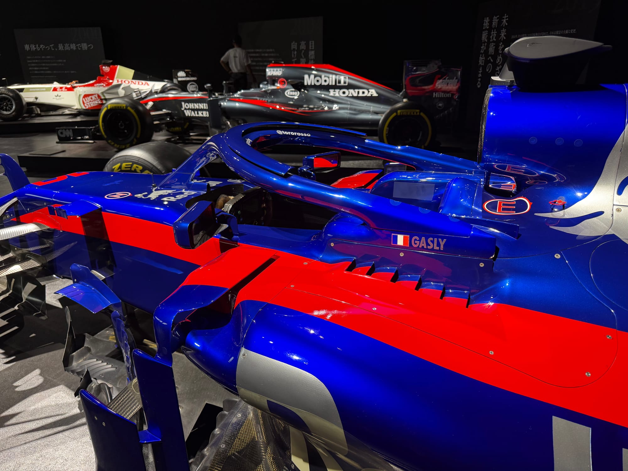 Scuderia Toro Rosso STR13 Formula One car displayed at the Honda Racing Gallery, showing Honda branding, Pierre Gasly's name and the blue, red and silver livery used during 2018.