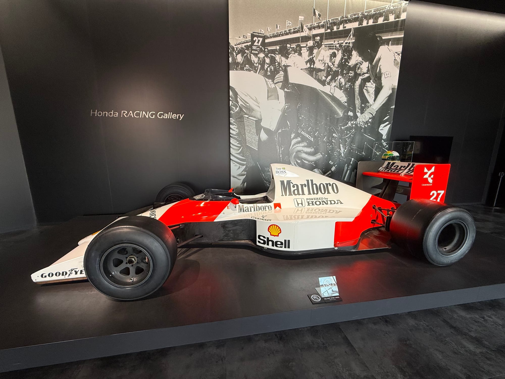 McLaren-Honda MP4/6 Formula One car displayed at the Honda Racing Gallery, featuring the iconic red-and-white Marlboro livery and race number 27.