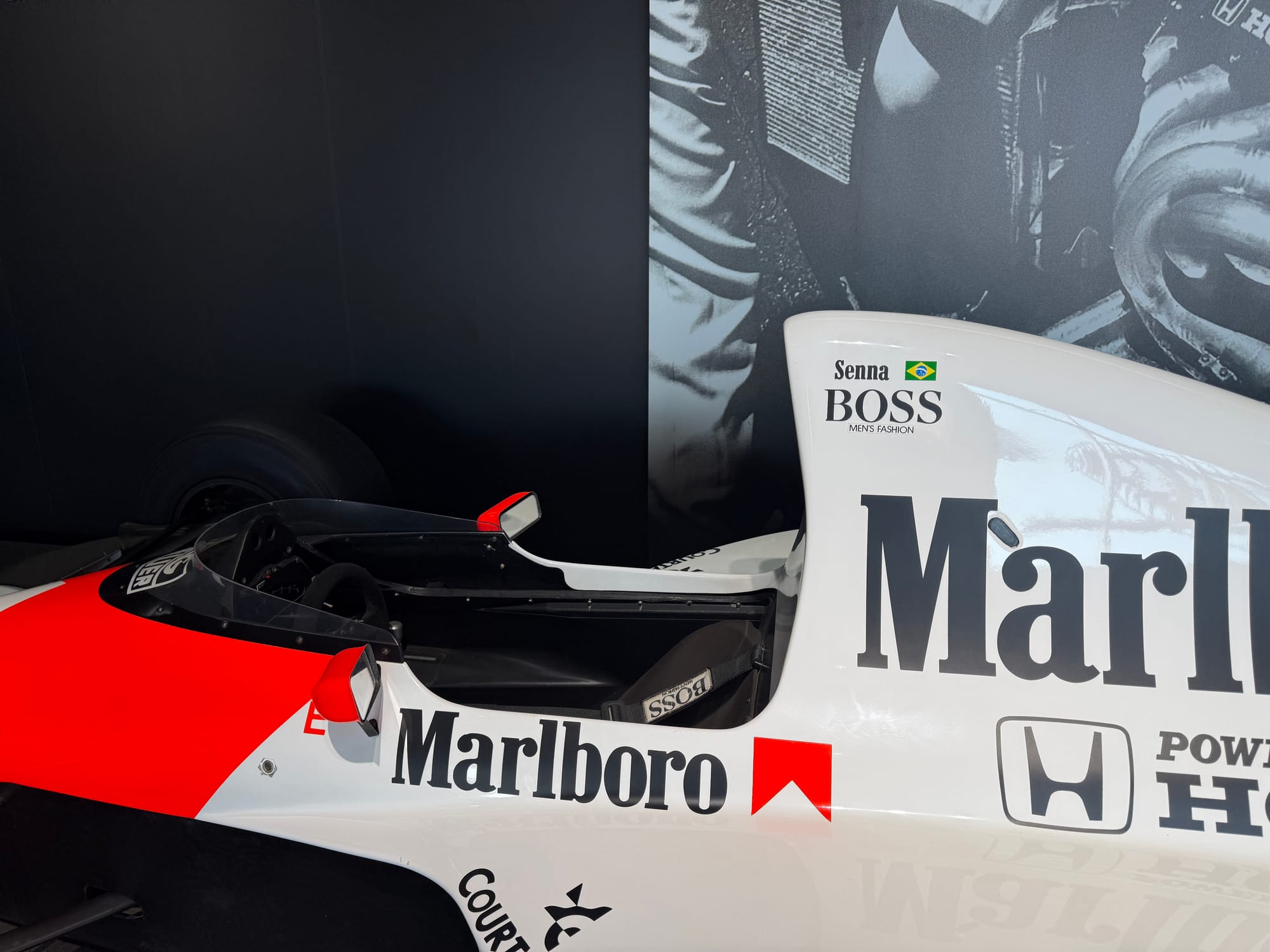 Close-up of the cockpit area of Ayrton Senna's McLaren-Honda MP4/6 Formula One car, showing the Marlboro livery, Honda branding and Senna nameplate.