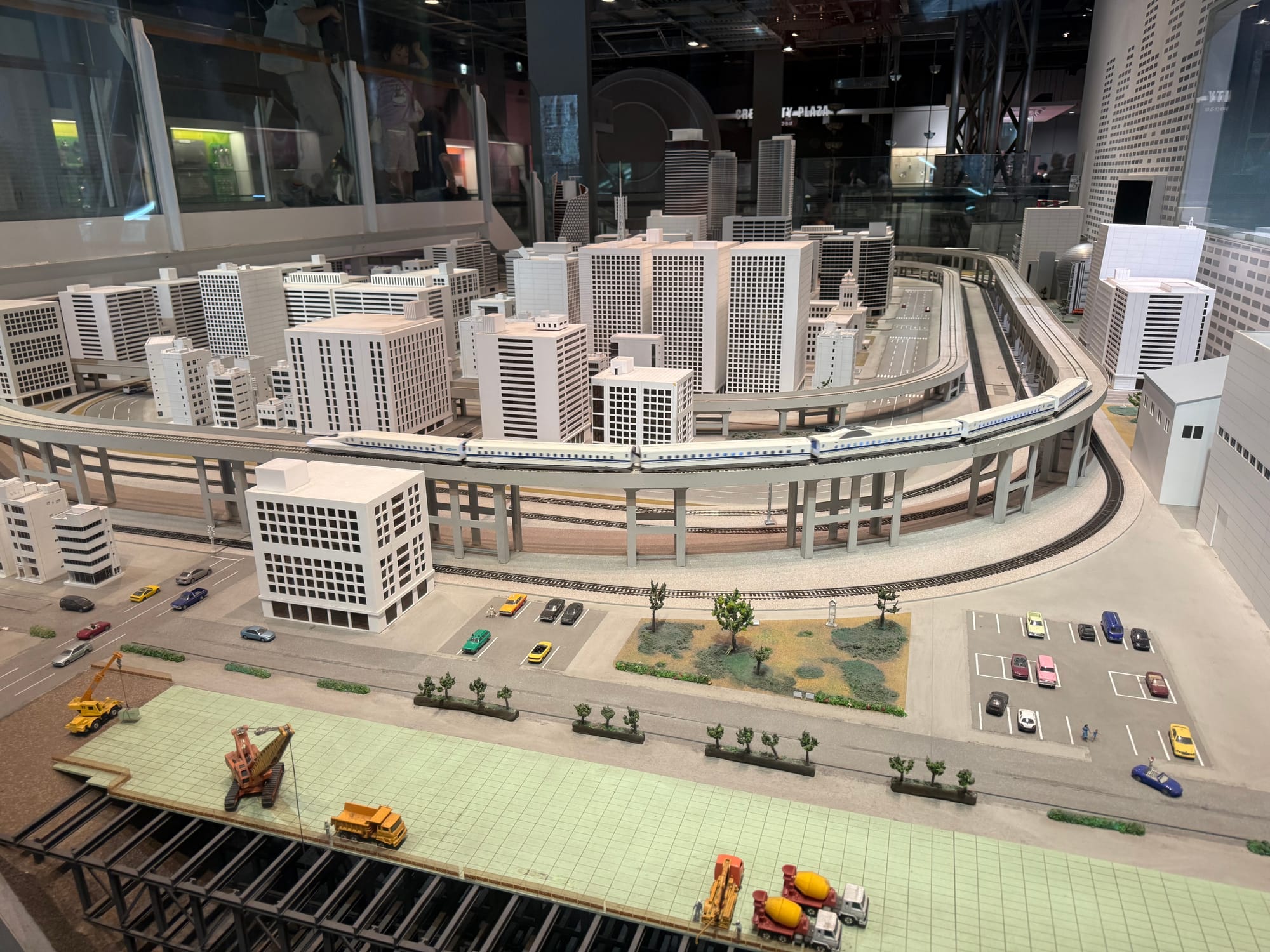 Scale model of a modern city with elevated rail lines and Shinkansen trains, displayed at the Nagoya City Science Museum to illustrate urban transportation systems.