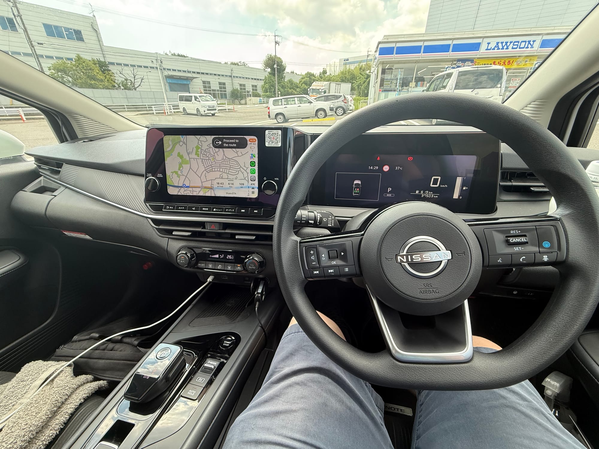 Interior of a Nissan Note e-POWER, showing the steering wheel, digital instrument display, navigation screen and centre console in a right-hand-drive configuration.
