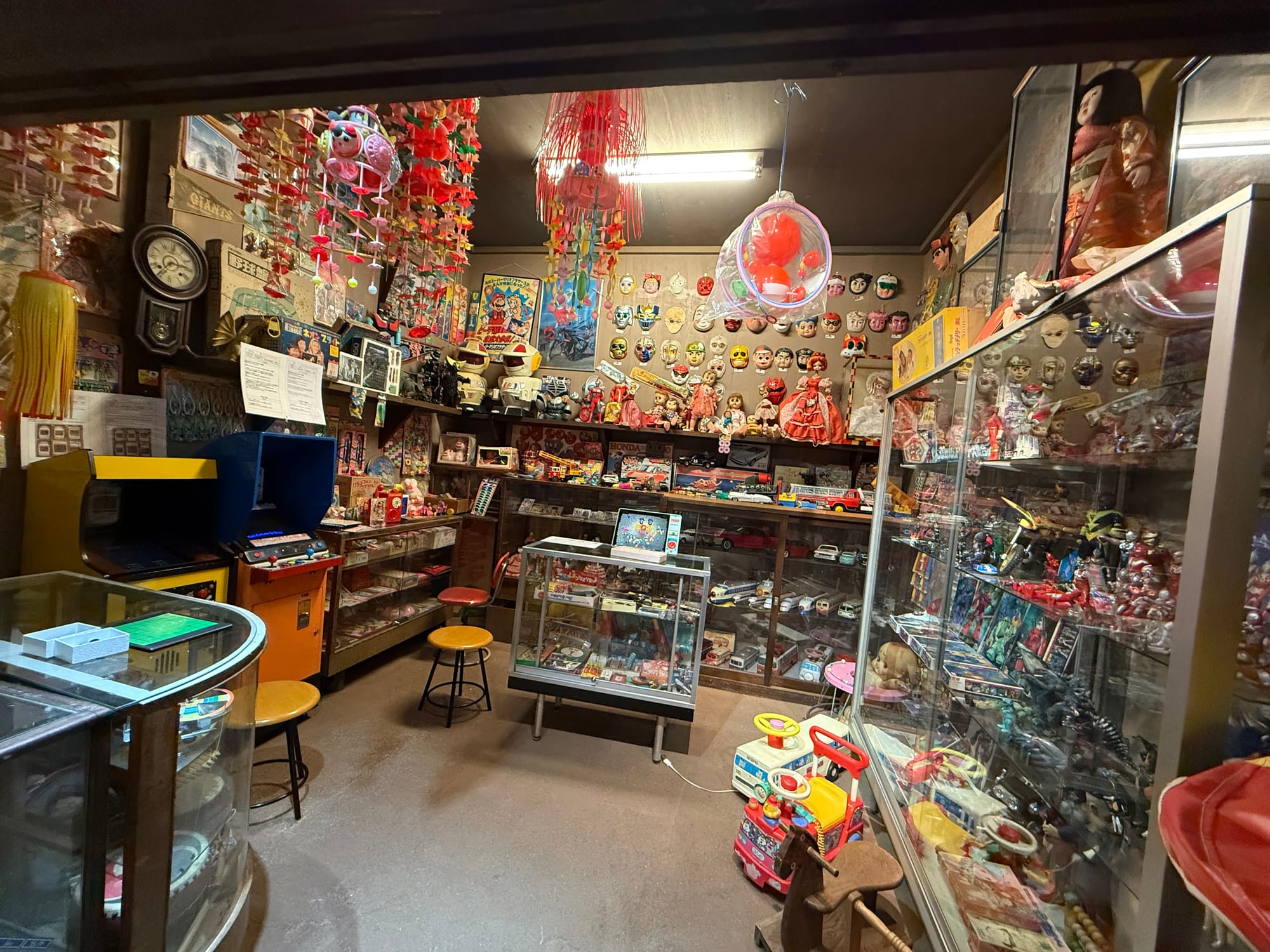 oy and memorabilia display at the Takayama Showa-kan Museum, featuring vintage dolls, masks, model vehicles, arcade machines, robots and children's toys from the Showa era.