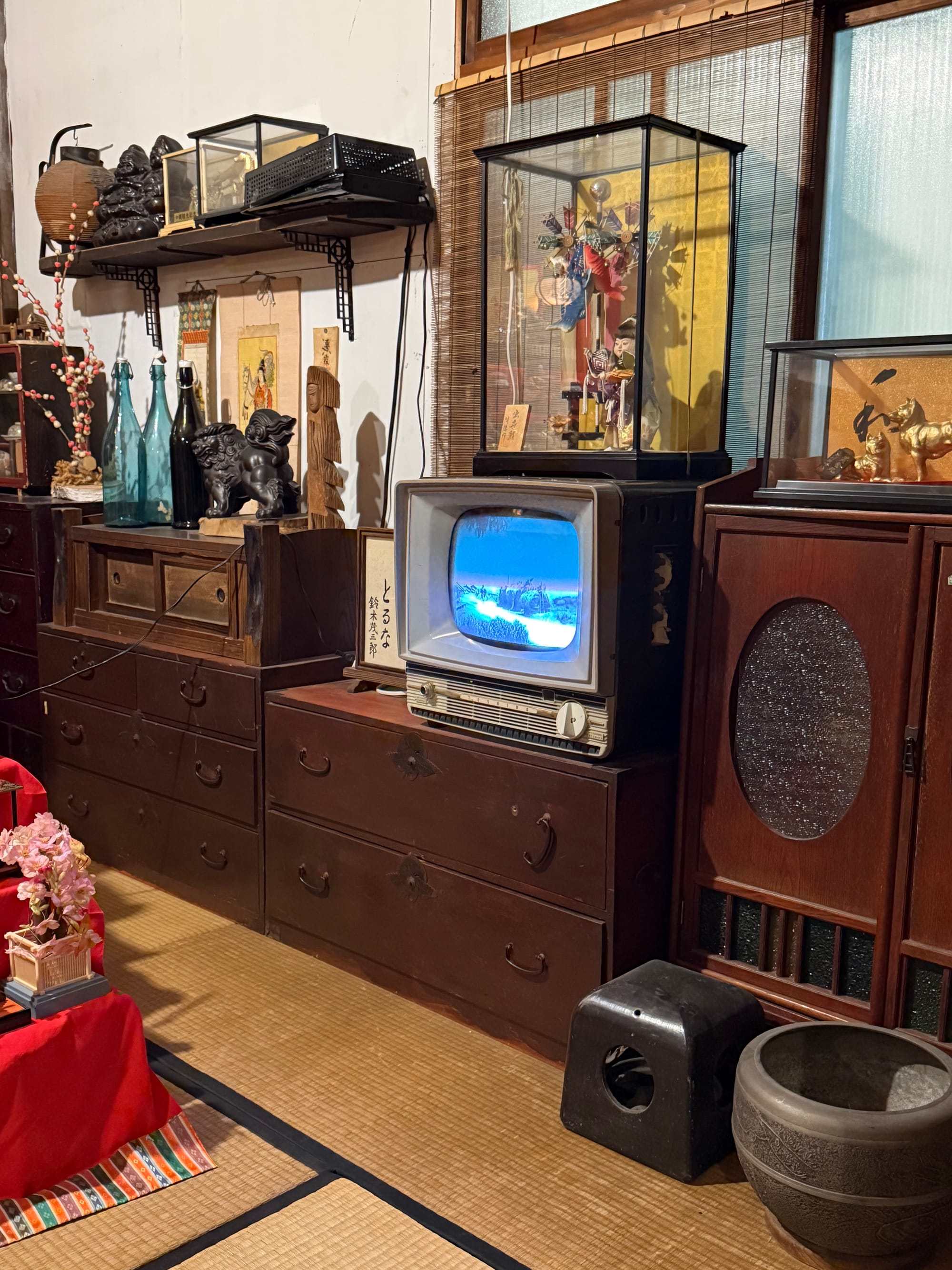 Showa-era living room display at the Takayama Showa-kan Museum, featuring a vintage television, wooden cabinets, traditional furnishings and decorative ornaments.