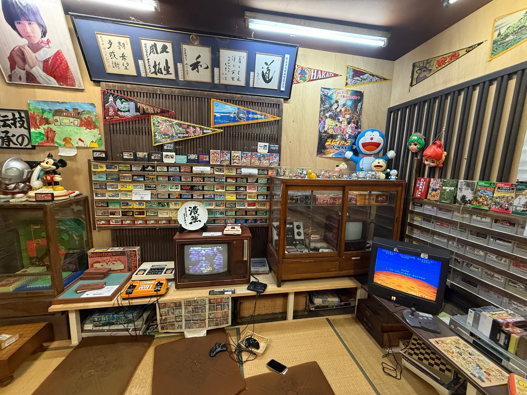 Showa-era gaming and pop culture room at the Takayama Showa-kan Museum, featuring vintage game consoles, cartridge games, televisions, toys, manga and anime memorabilia.