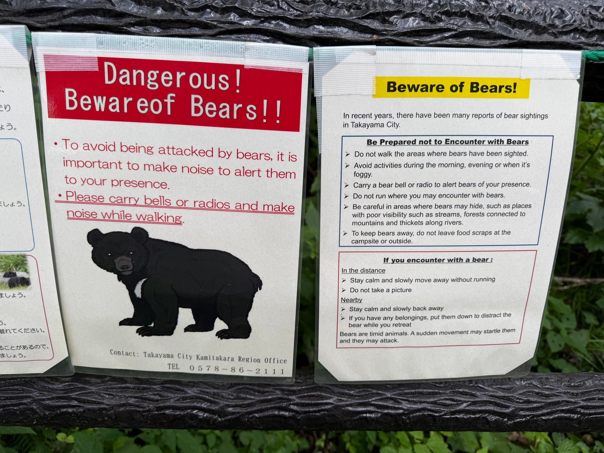 Bear warning signs near Hirayu Great Falls, displaying safety advice in English and Japanese, including guidance on avoiding encounters with Asian black bears in the area.
