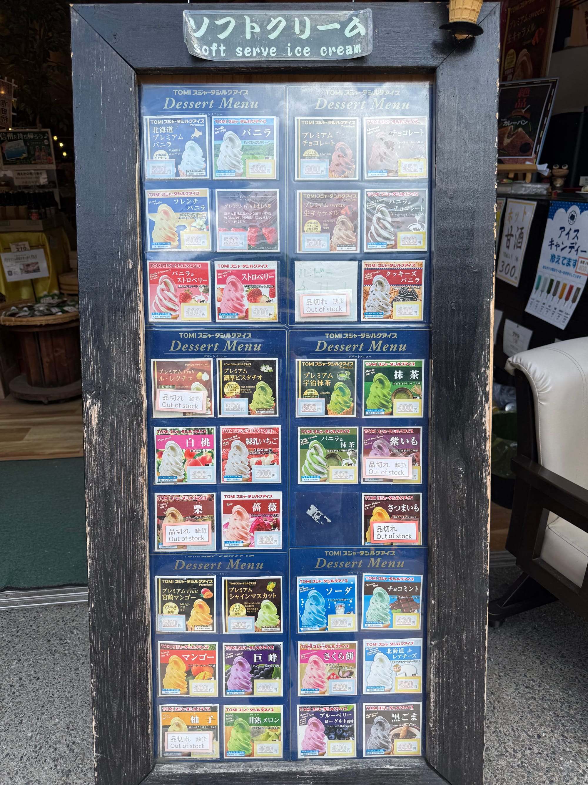 Soft-serve ice cream menu outside a shop in Narai-juku, displaying a wide range of flavours including ramune, matcha, melon, mango, peach, strawberry and black sesame.