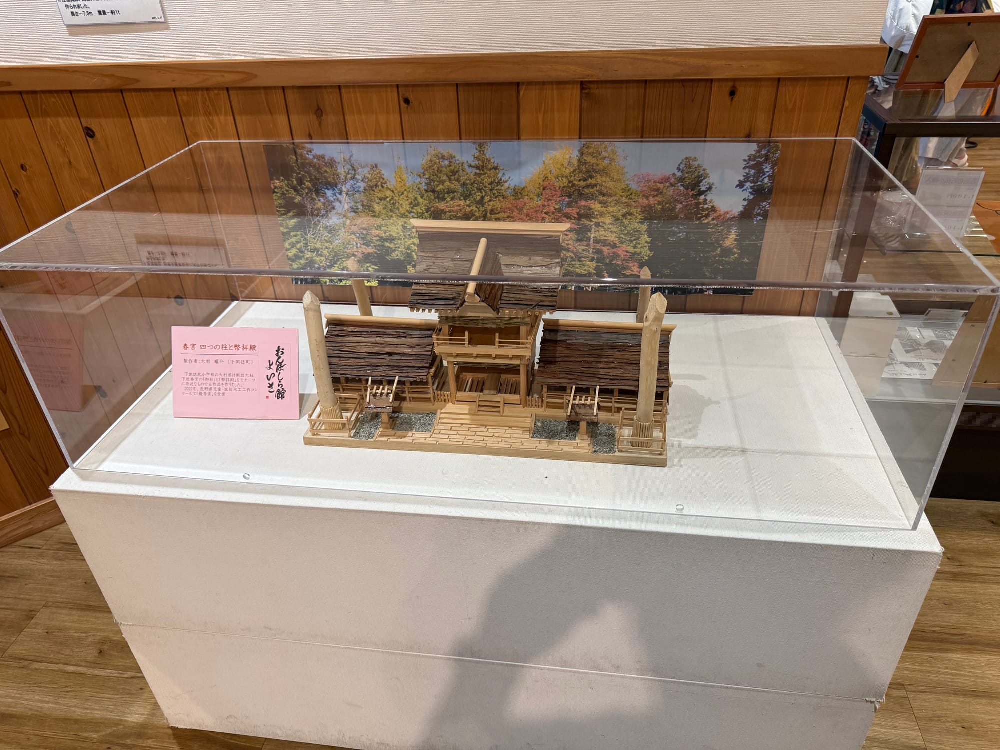Scale model of Suwa Taisha Shimosha Harumiya displayed at Onbashira-kan Yoisa, showing the shrine buildings and the four sacred Onbashira pillars at the corners.